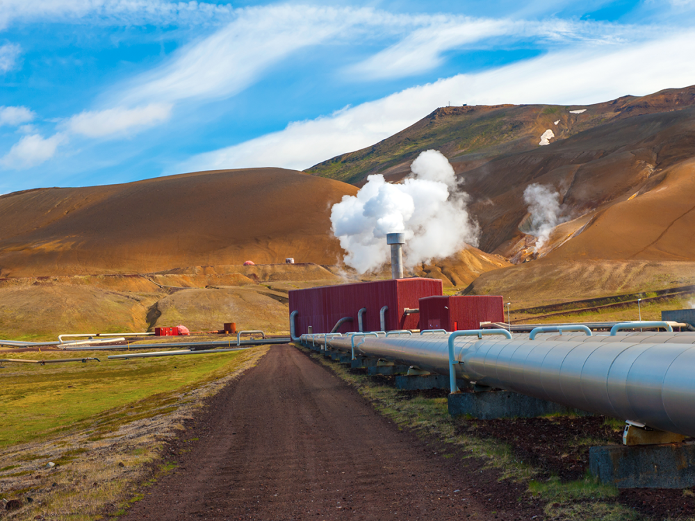 Photo of geothermal plant and rising mountains