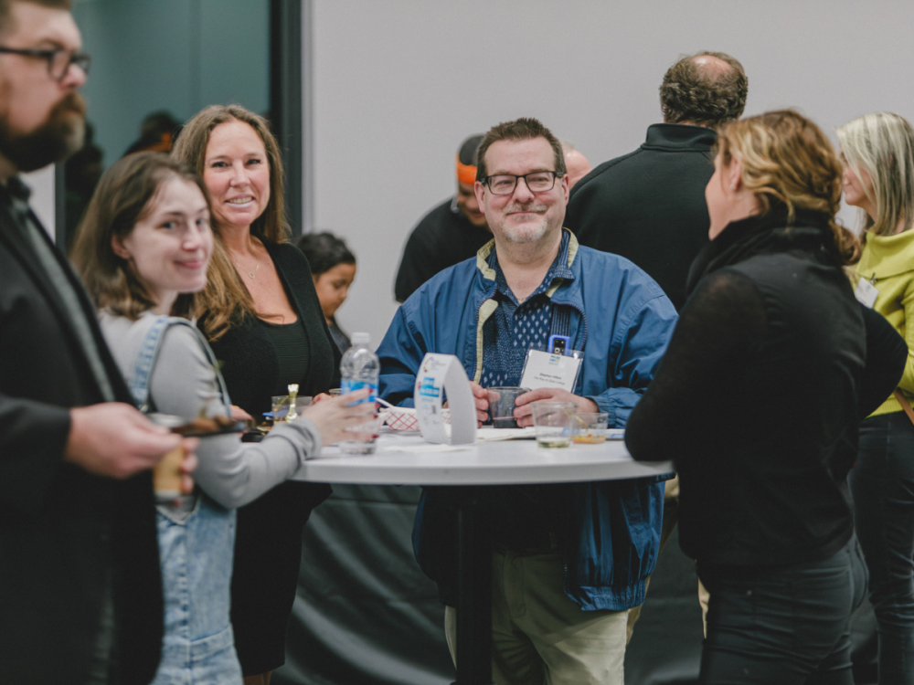 People networking around a standing table