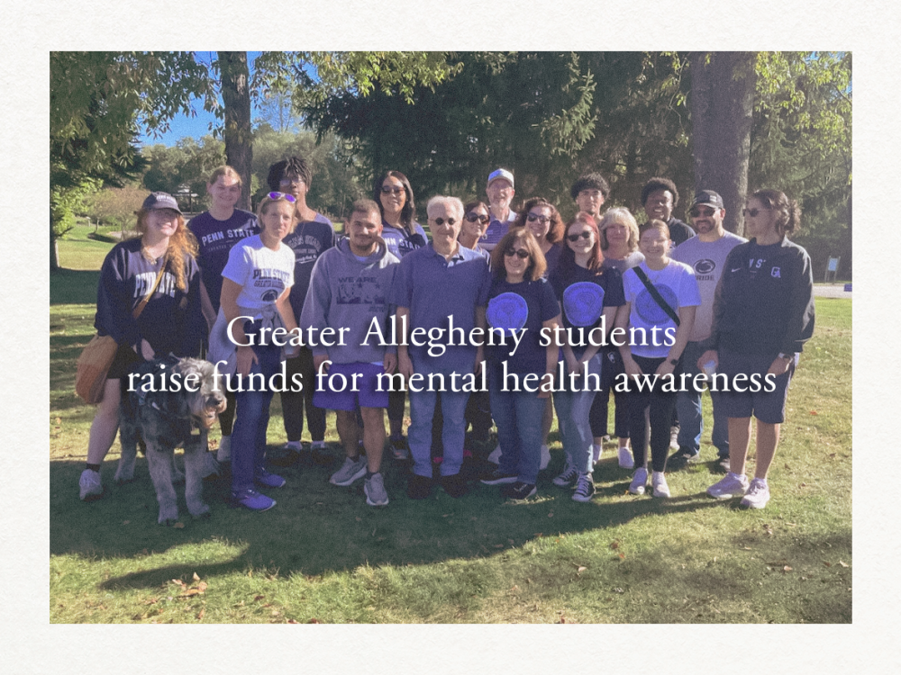 A group of faculty, staff, and students from Penn State Greater Allegheny stand together outdoors on a sunny day during the annual NAMIWalks event. Many are wearing Penn State or event t-shirts, smiling for the photo.