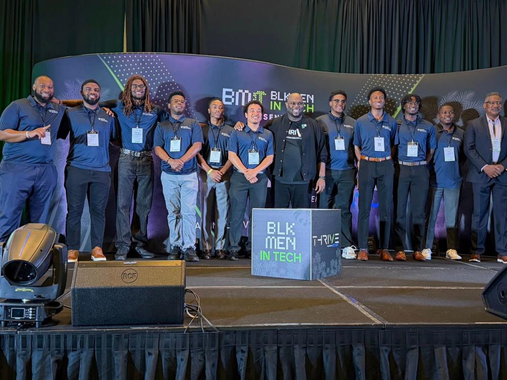 group of people stand in a line on stage at conference