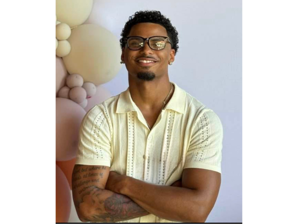 A male, criminal justice student, Keyon Moore, smiles at the camera