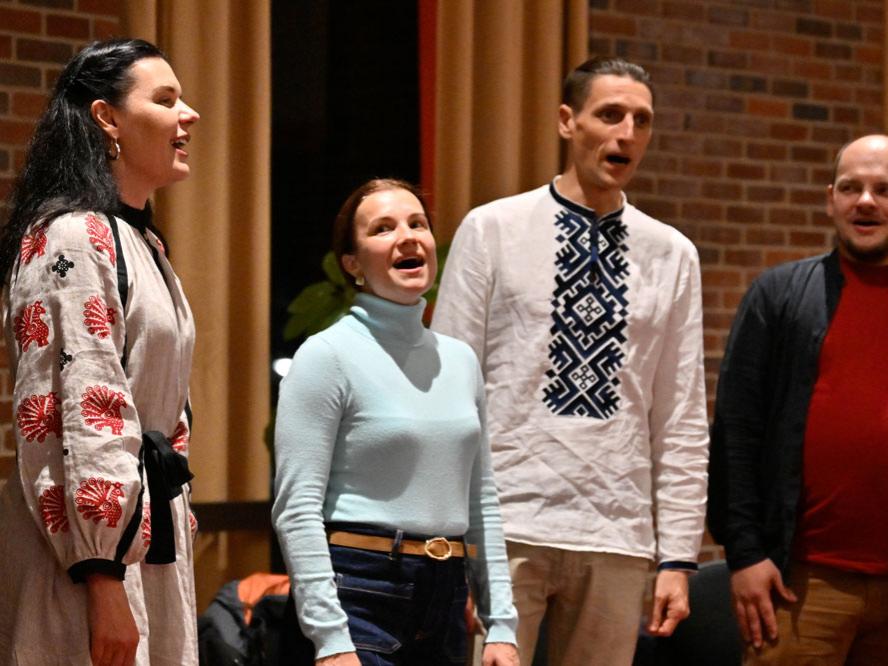 Two women and two men sing in unison.