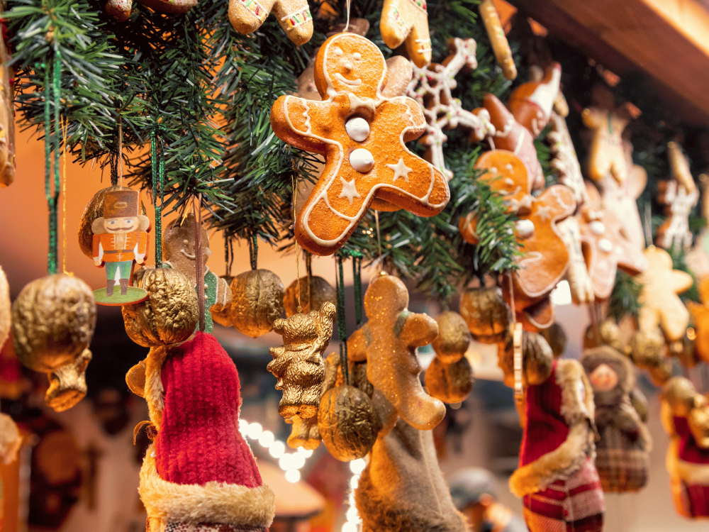 A collection of miscellaneous holiday decor and crafts hanging near greenery