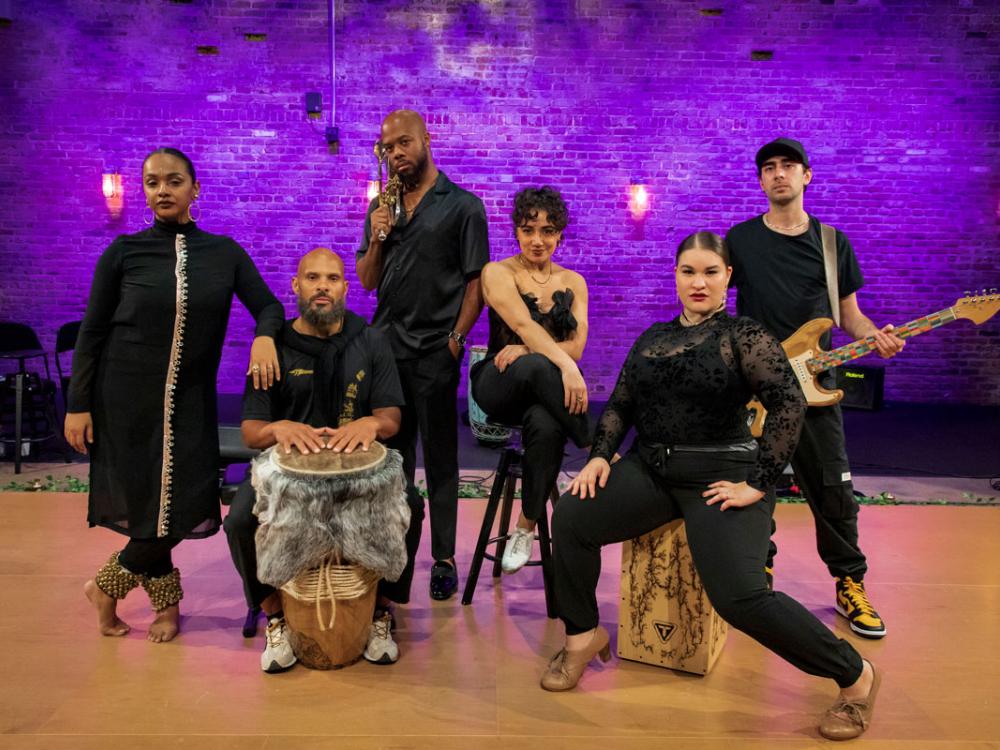 A diverse group of of men and women hold a pose or an instrument.