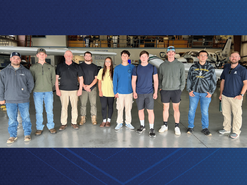 A group of students inside an airplane hangar at Keystone Aerial Surveys, Inc.