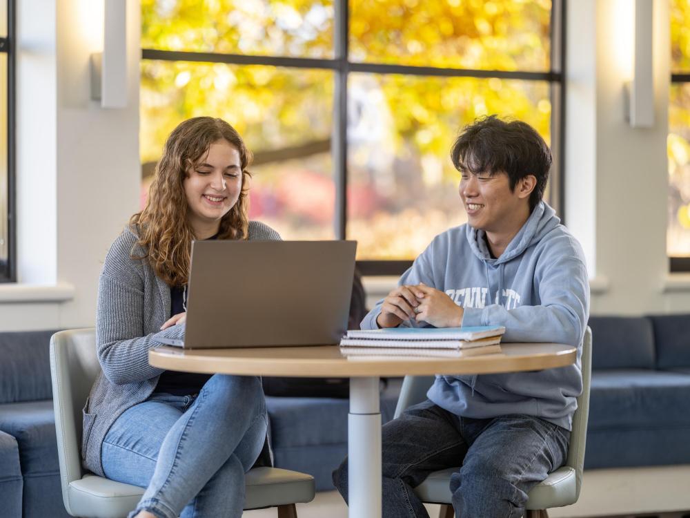 Two people talking and studying at table
