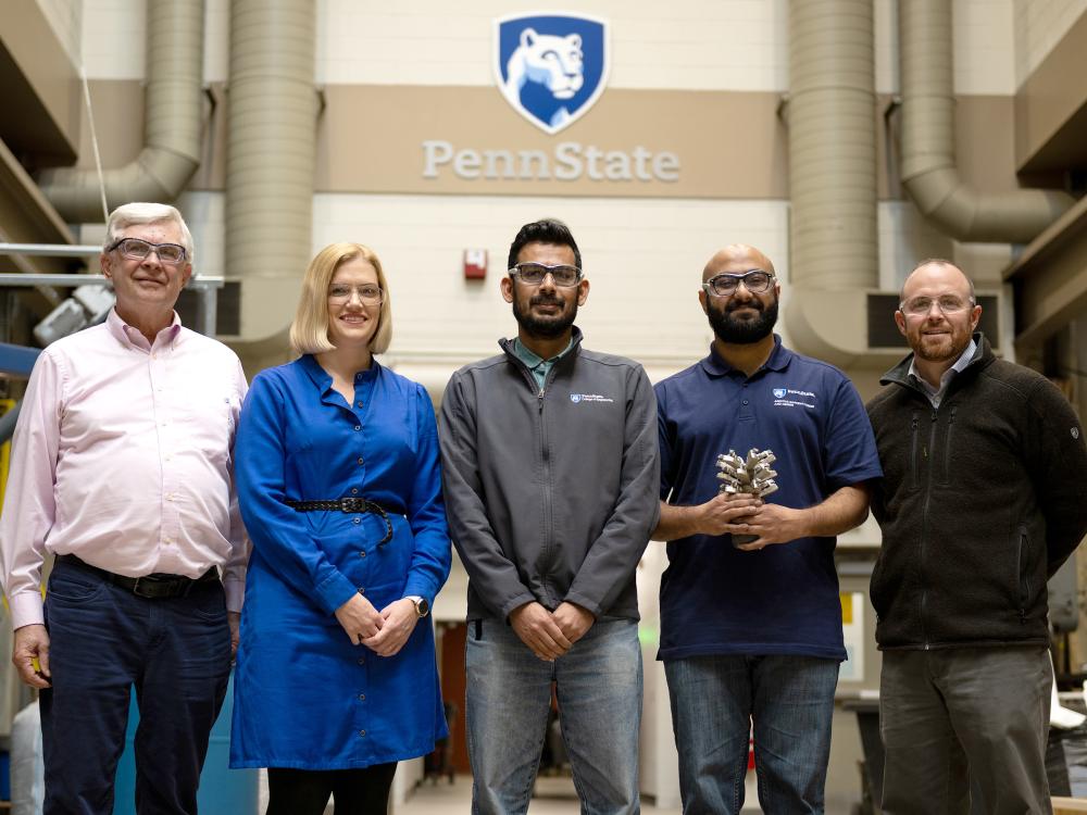 Group of researchers including Robert Voigt, Katie Fitzsimons, Guha Manogharan, ​Vignesh Raman and Craig Dubler, posing in a Penn State-branded lab