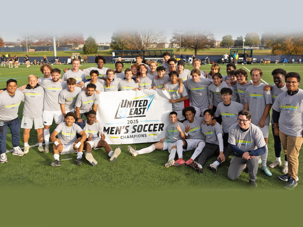 Penn State Harrisburg men's soccer players hold a banner that says United East 2025 Men's Soccer Champions