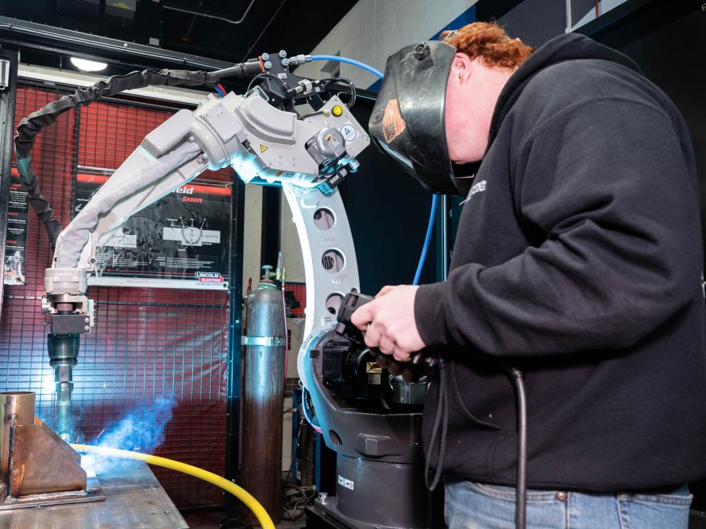 A person uses a welding sysem in a workshop