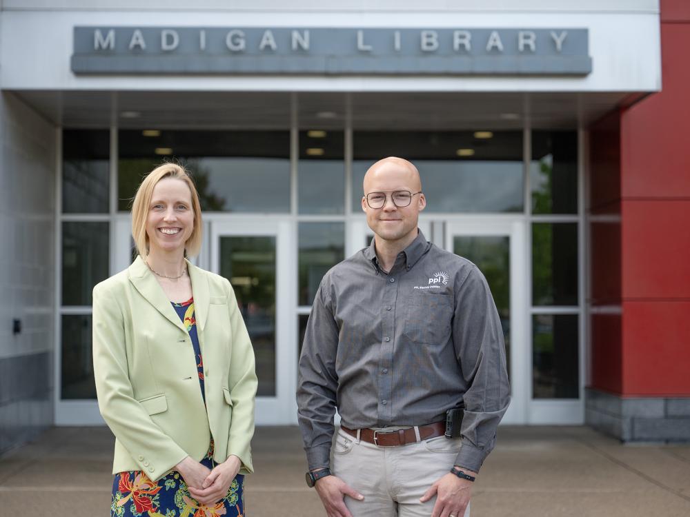 Two people standing in front of a building entrance