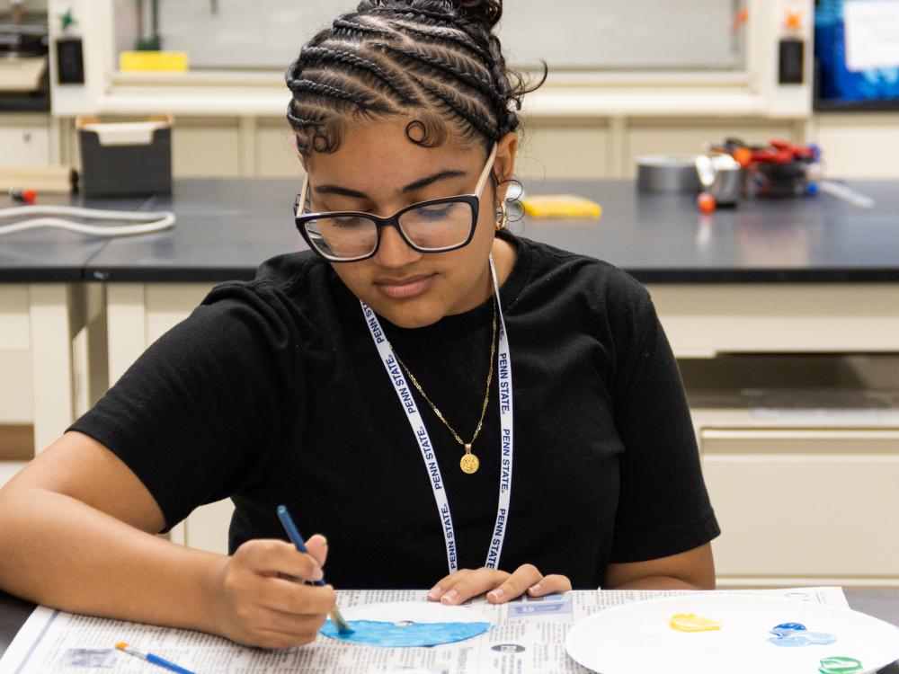 Student participating in the Uplifting Science camp painting.