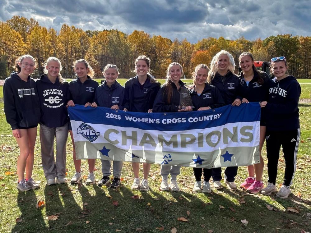The Penn State Behrend women's cross country team poses with the AMCC championship banner.