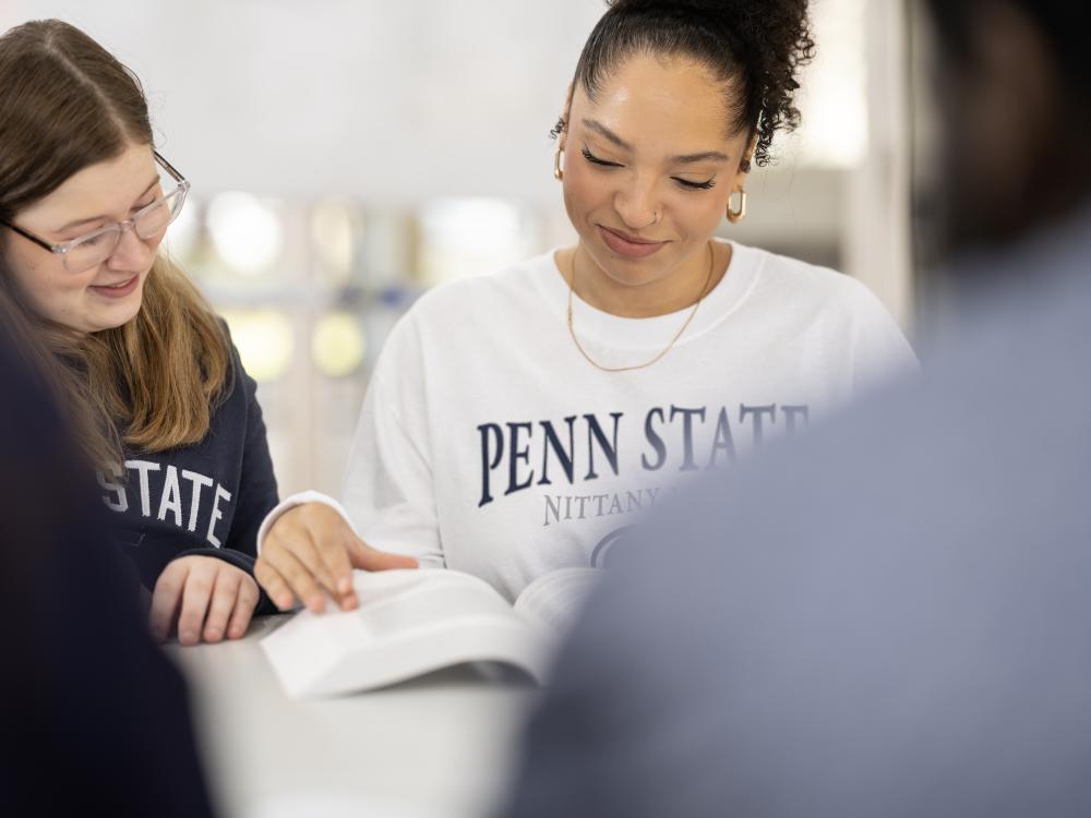 A pair of students studying from a textbook
