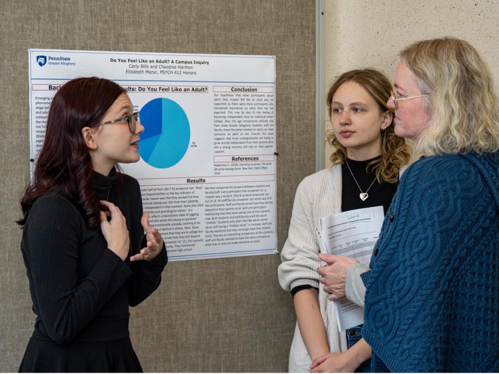 Student researchers Chazdine Harmon (left) and Carly Bills (middle), present their poster to guest judge and head librarian at Penn State New Kensington Jennifer Gilley (right)
