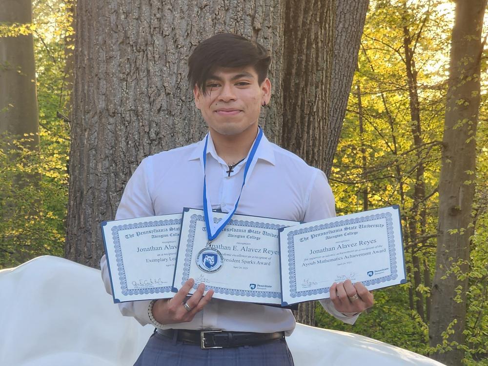 Jonathan poses with academic awards