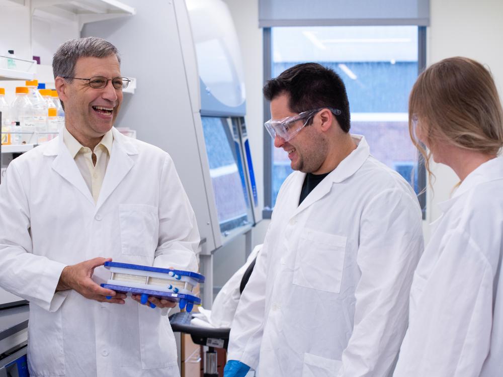 Three people conversing in a lab