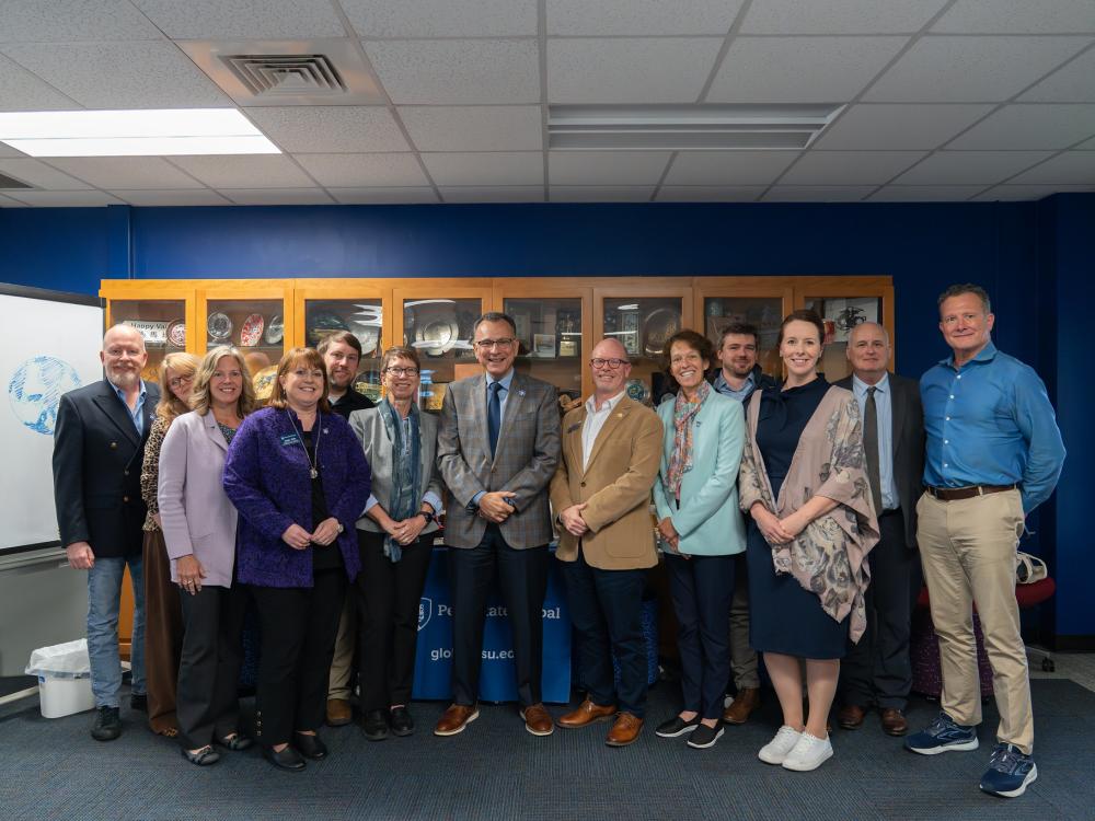 A group of people posing for a picture in front of a cabinet