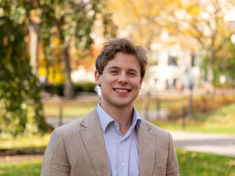David Gross stands in front of trees during autumn at Penn State University Park.