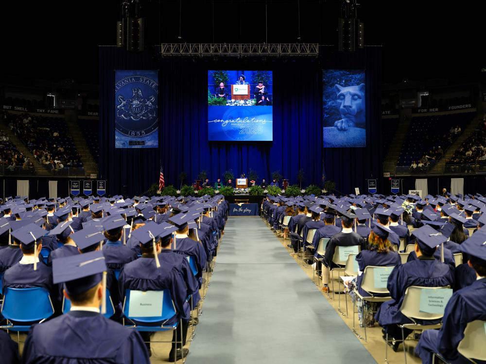 A wide photo of graduates facing the graduation stage during a ceremony