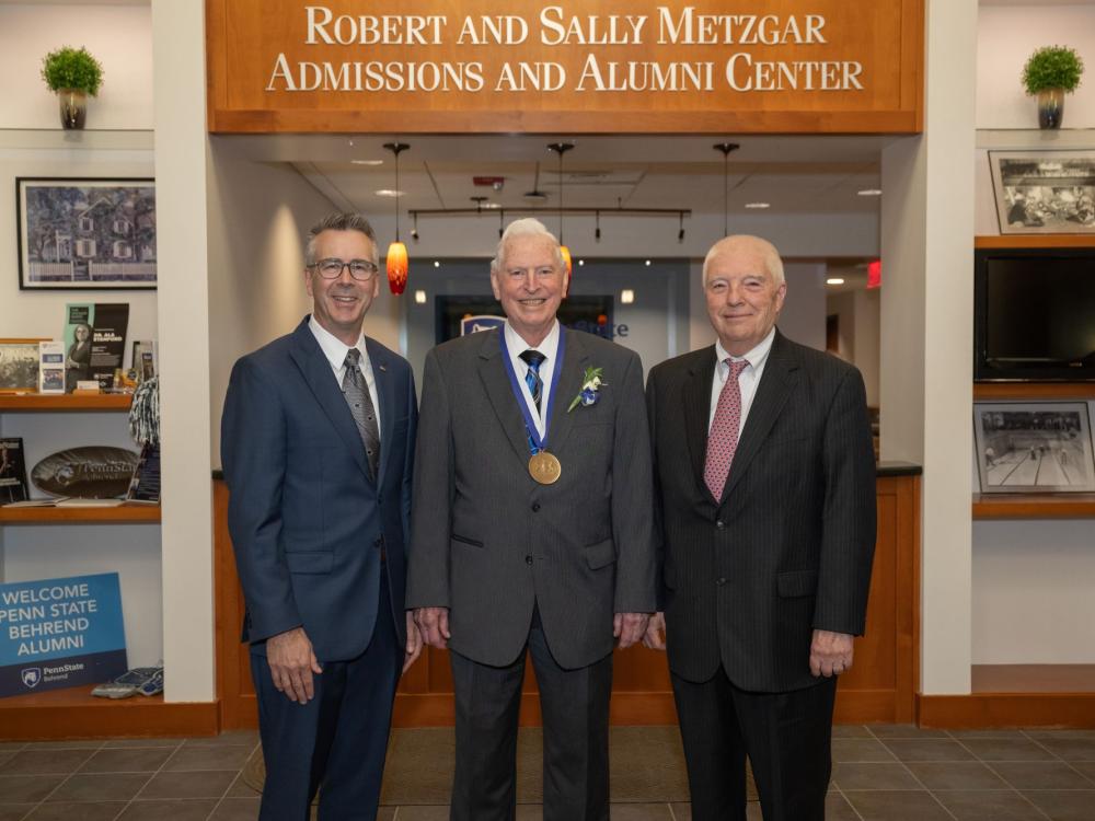 Penn State Behrend Chancellor Ralph Ford and former Chancellor Jack Burke pose with Robert D. Metzgar, who wears the Behrend Medallion.