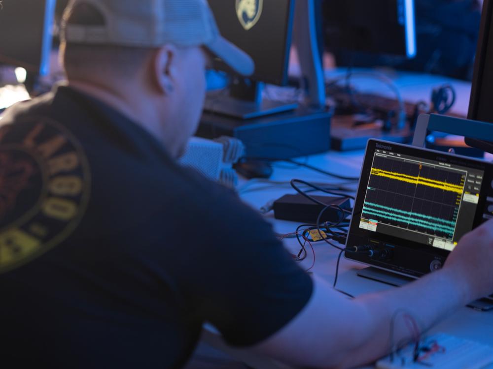 An engineering student examines waveforms on a digital oscilloscope