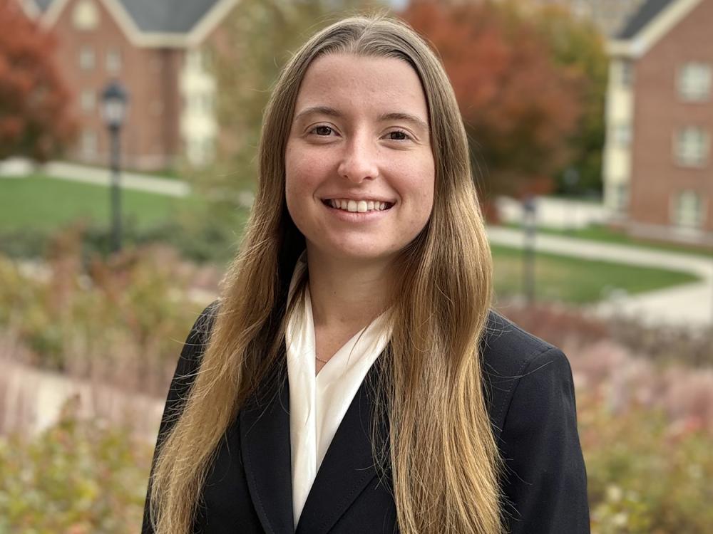 A head and shoulders photo of Lauren Clymer, who is wearing a black blazer and white scarf.