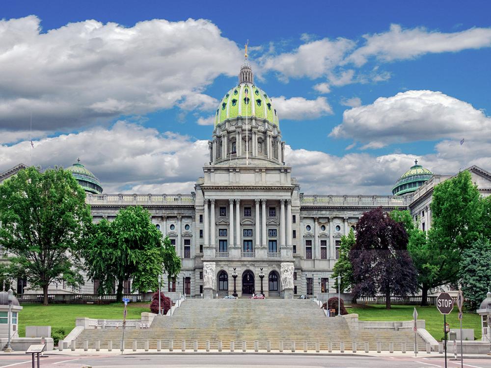 Large, green-domed building with staircase and trees