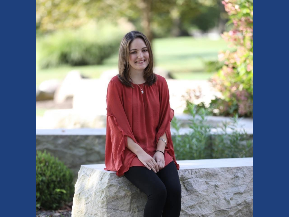 Danielle Guth sitting on stone at Penn State Brandwywine