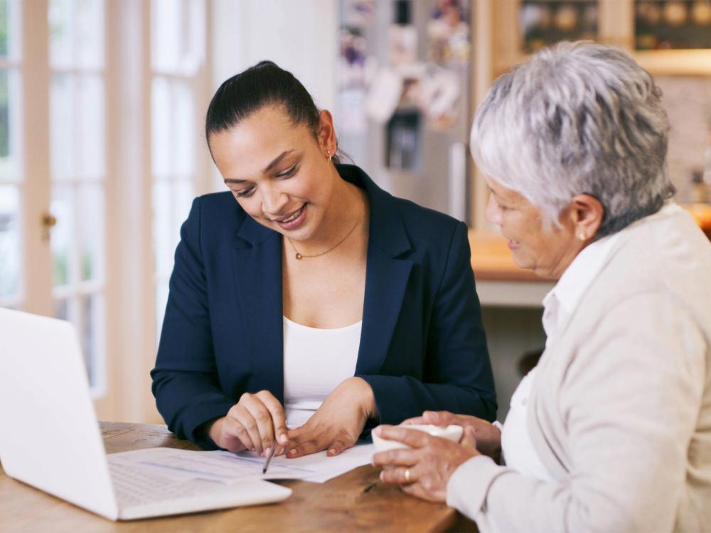 Woman and nurse with tablet for consultation with expert advice explaining healthcare support.