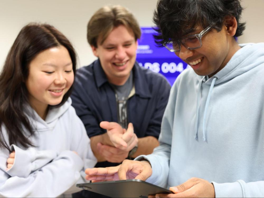 Sai Anurag Sudagauni demonstrates 3D scanning technology for two student participants. 