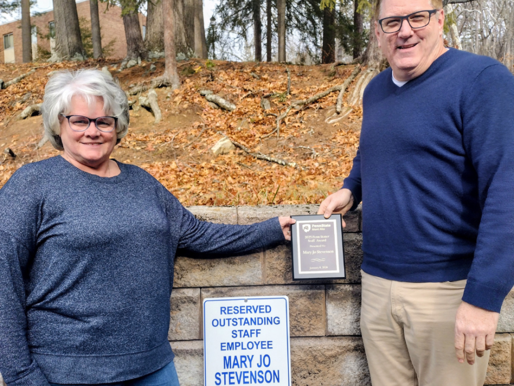 Penn State Mont Alto Chief Student Affairs Officer Jay Arcuri presents award winner Mary Jo Stevenson with her plague and parking sign