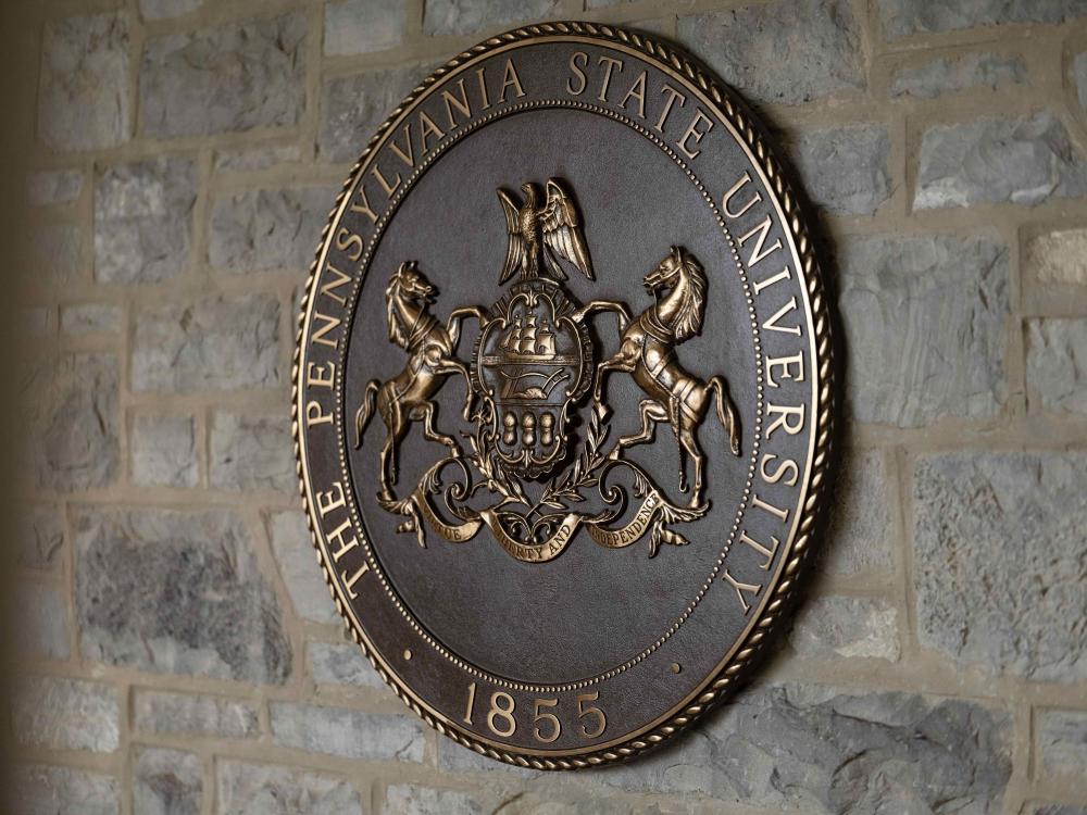 The Pennsylvania State University seal on a stone wall