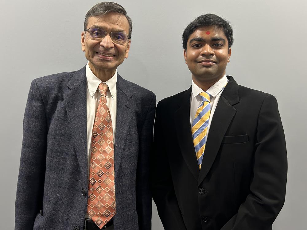 A photo of Smeal faculty member Akhil Kumar and senior student Om Dobariya standing shoulder to shoulder in suits and ties