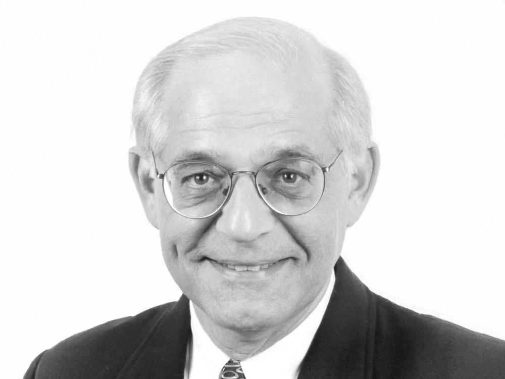 A black and white photo of smiling R. William Millman