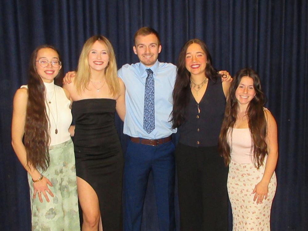 Five Penn State Behrend students -- four women, with a man in the middle -- pose before a THON event.