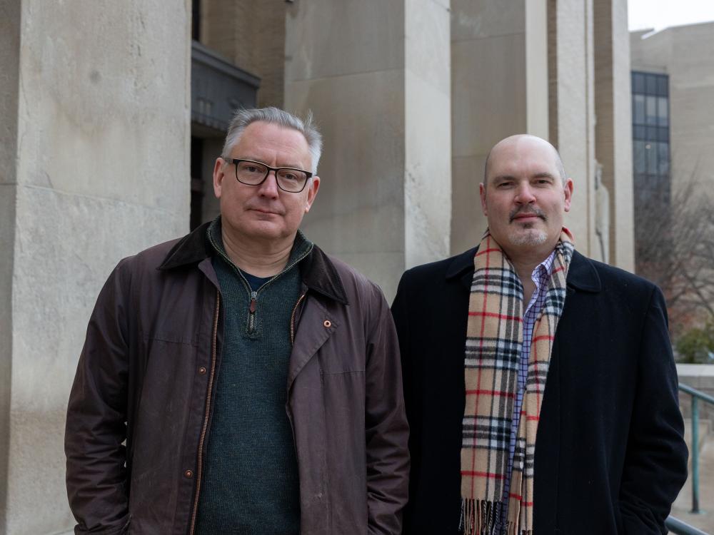 Liberal Arts faculty Michael Kulikowski on left and Brad Vivian on right standing on steps of Pattee Library