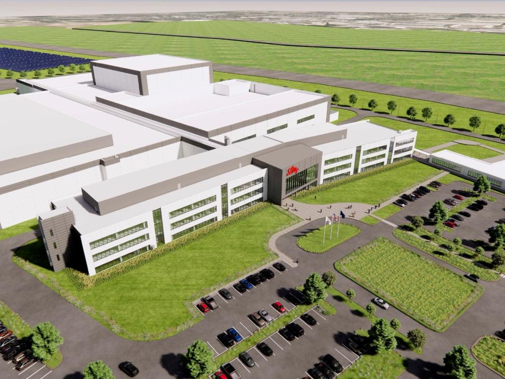 a large warehouse building surrounded by a parking lot and grassy areas