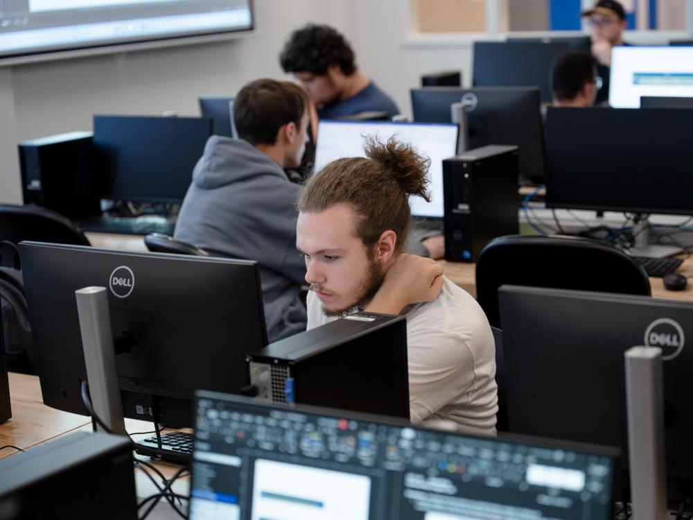 A student works at a computer in a computer lab.