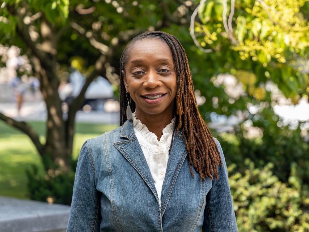 Sherita Johnson wears a blue jacket and white blouse while standing on Penn State's campus. 