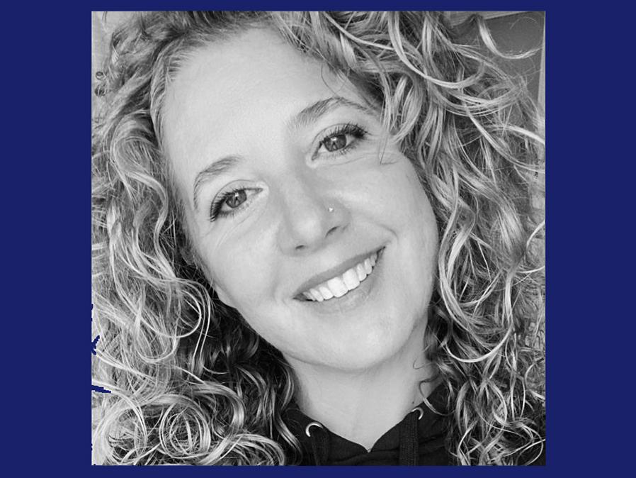 Head shot image of a white woman with blonde hair smiling