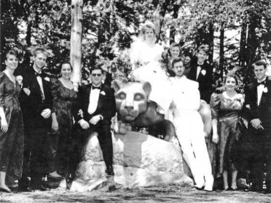 A black and white picture of a wedding party at the Nittany Lion shrine