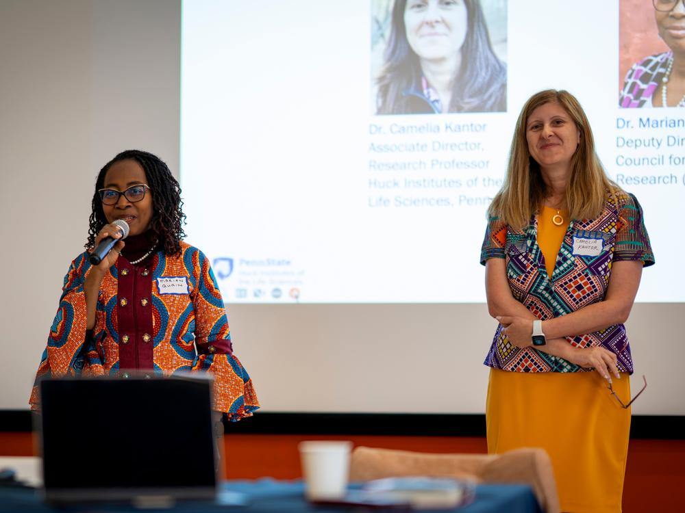 Two women standing in front of a projector screen