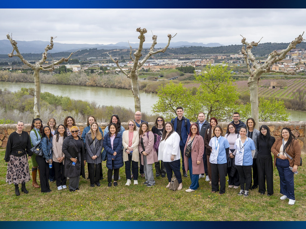 A group of people posing in front of a grassy valley area.