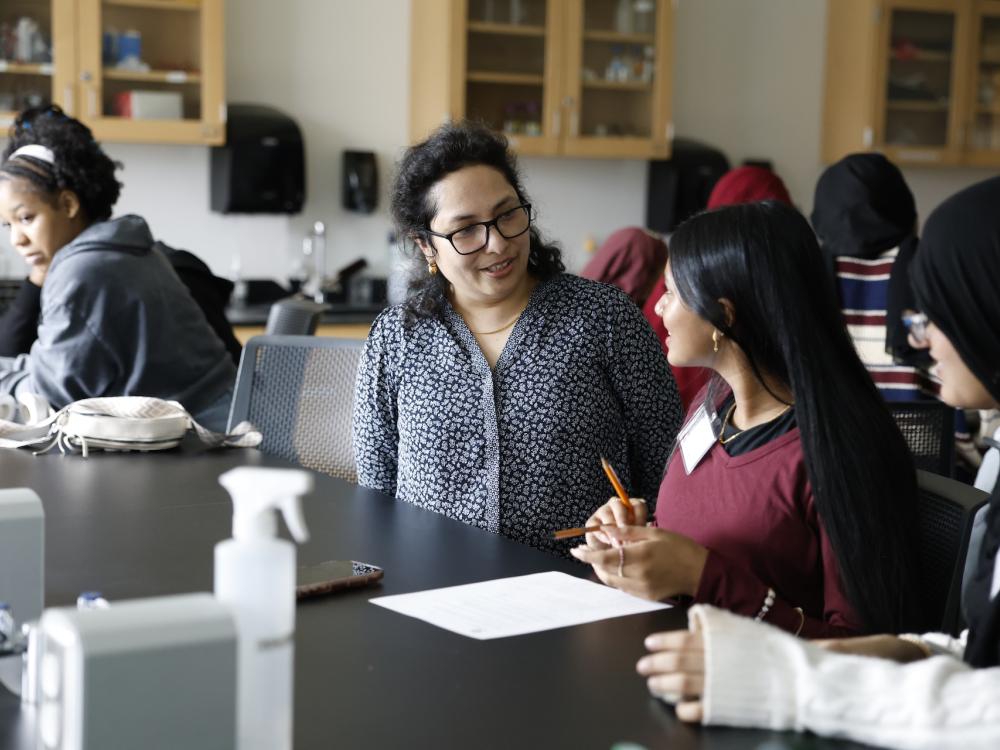 professor talking with high school students in a lab