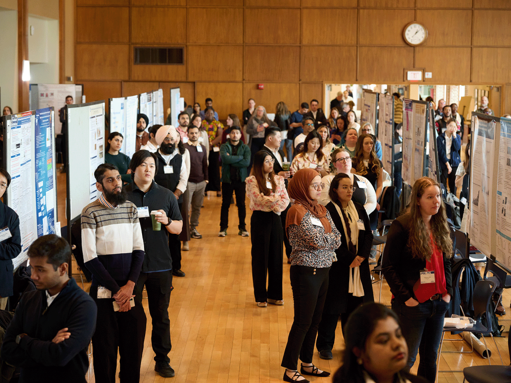 2025 Graduate Exhibition participants wait for the event to begin in front of their research posters