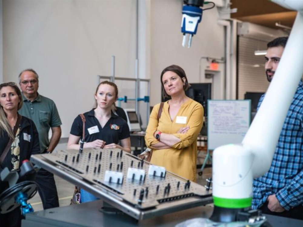 Five individuals stand in the Penn State Digital Foundry surrounded by technological tools and equipment