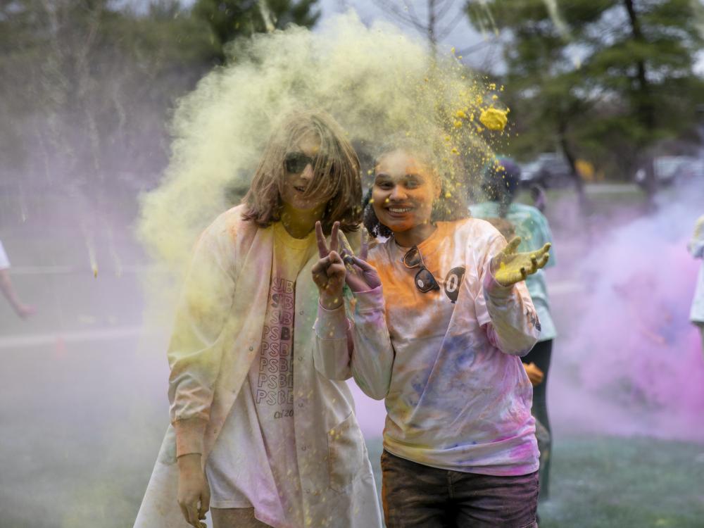 Students covered in colored powder pose duing last year's Holi celebration.
