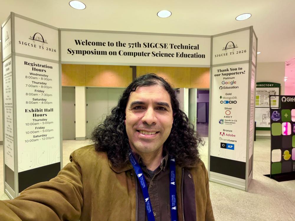 smiling person with long dark hair at computing conference