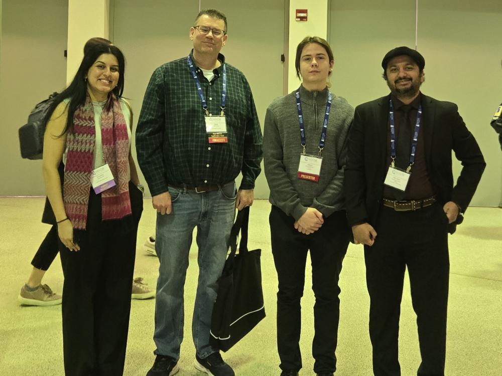 four people standing next to each other