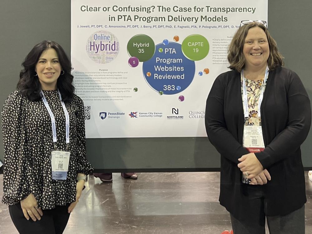 Emily Fagnelli and Jen Jewell pose for a photo in front of a poster presentation hanging between them.
